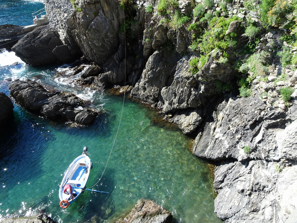 Small boat in a clear water cove in Manarola